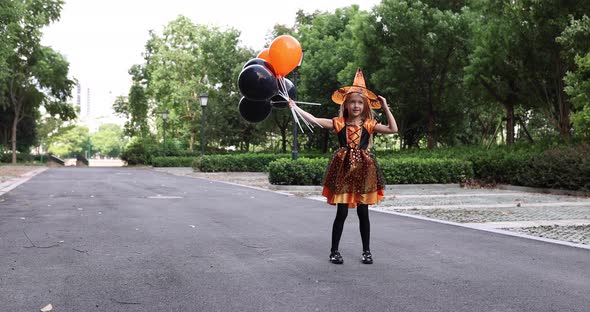 Cute Little Caucasian Girl with Blonde Hair Seven Years Old in Costume of Witch with Hat and Black