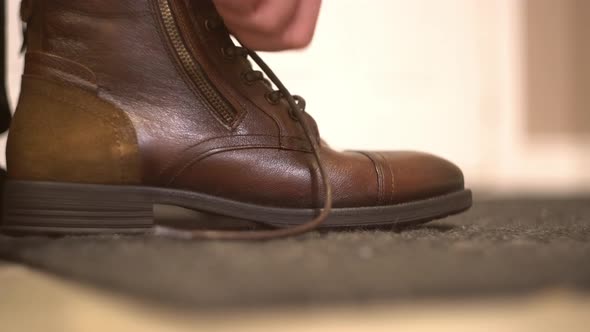 Zipping and tying brown leather boots shoes and trying on shoes from online shopping