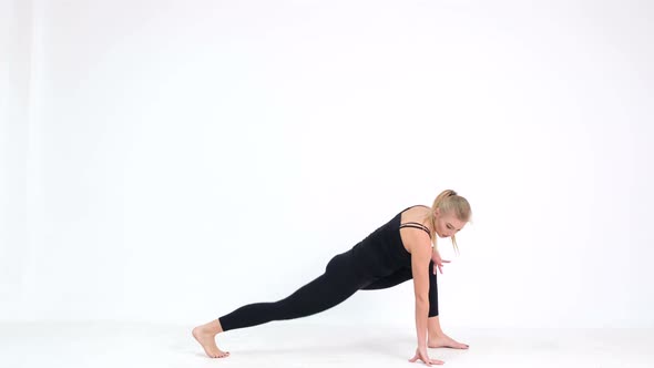 Young woman demonstrates a yoga pose on a white background.