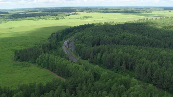 Aerial View of the Train That Goes Through the Forest and Fields