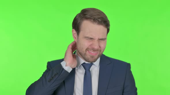 Young Businessman with Neck Pain on Green Background