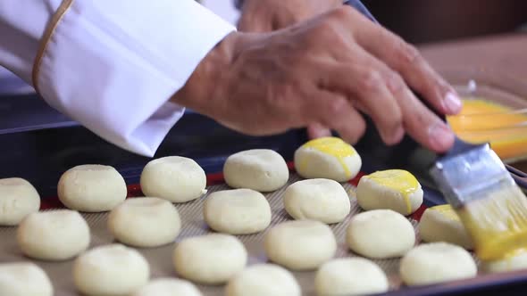 Chef Greases the Cookie Dough with Egg Yolks Using a Brush