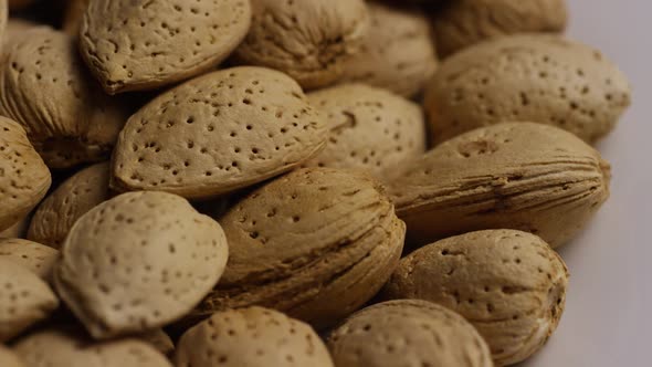 Cinematic, rotating shot of almonds on a white surface 