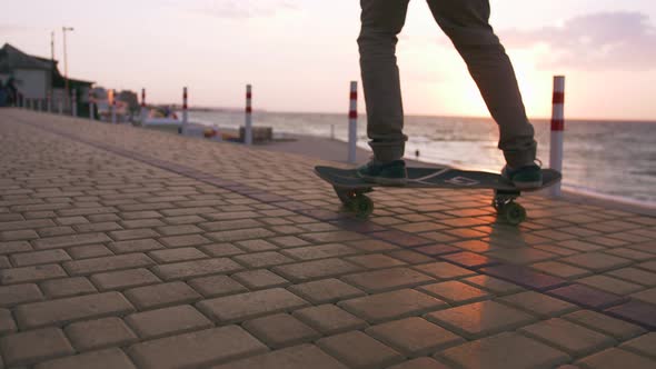 Close Up Shot of Young Man Skateboarding on the Road Near the Sea Slow Motion