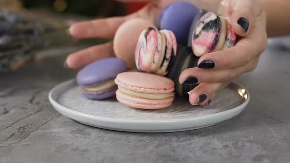 Female Chef Hands Putting Macaroons Into the Plate