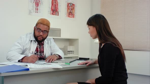 Male Doctor Signing Medical Paper in Exchange for Patient's Money