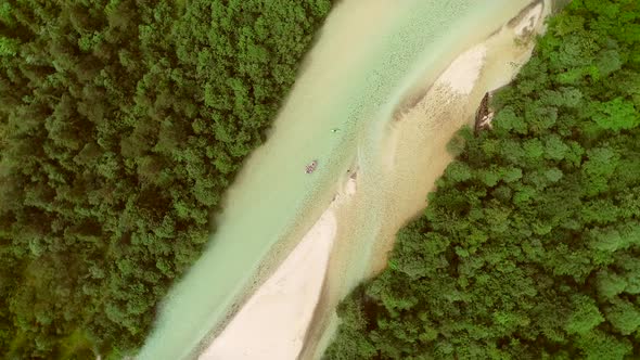 Aerial view of adventurers doing rafting surrounded by a big green forest.