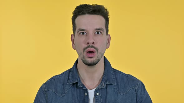 Portrait of Disappointed Young Man Feeling Shocked, Yellow Background