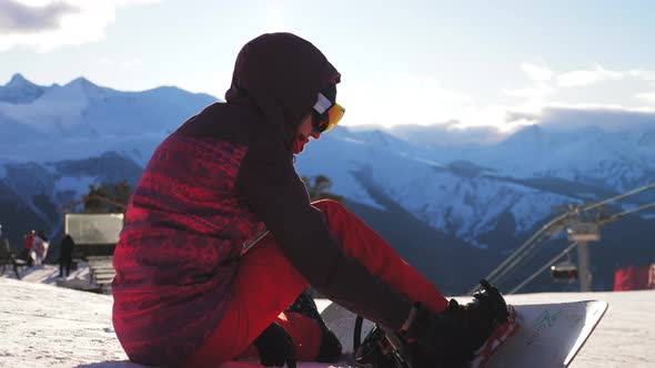 A Young Woman on a Snowboard on Top Mountain on a Ski Track