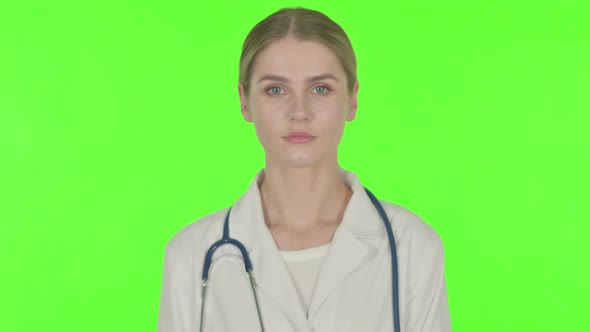 Serious Female Doctor on Green Background