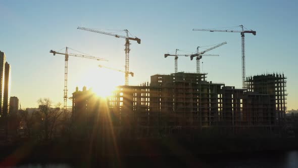 Several Construction Tower Cranes in the Process of Building Houses in a New Residential Complex at
