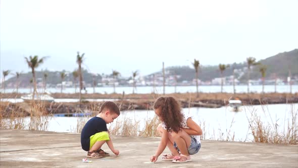 Funny Little Children Like To Play a Fun Game Together, Making Drawings with Colored Crayons