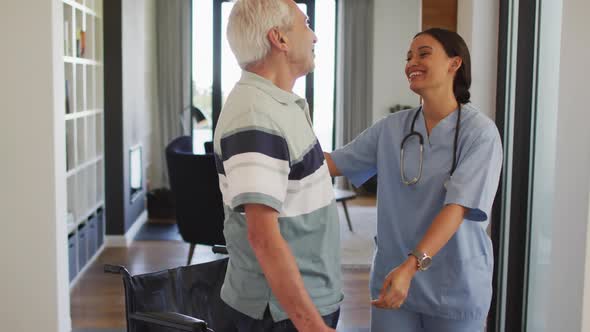 Animation of happy biracial female doctor taking care of caucasian senior man