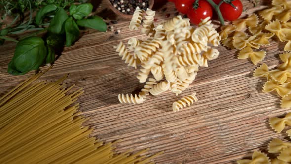 Super Slow Motion Shot of Fresh Fusilli Falling on Italian Decorated Wooden Table at 1000Fps