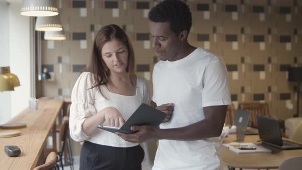 Caucasian and African American Coworkers Discussing Project