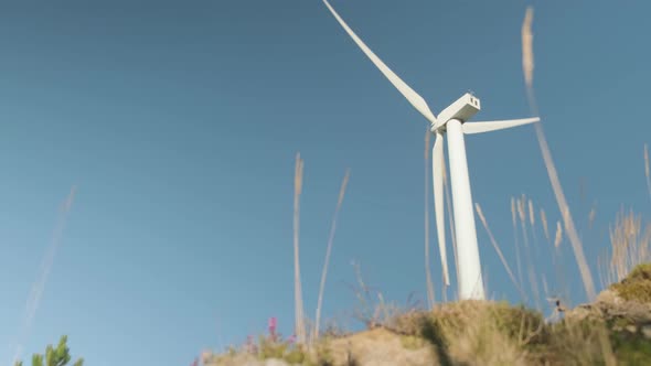 A single wind turbine spins and generates clean energy in Galicia, Spain