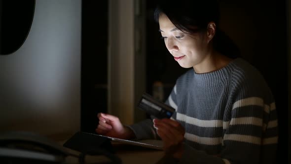 Woman using digital tablet computer for online shopping at night 