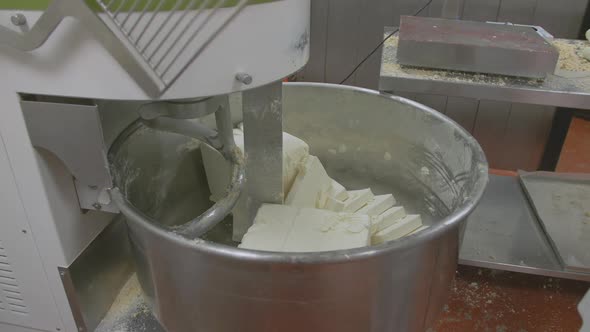 Slabs of icing mixture are added to an industrial cake mixer which is turned on