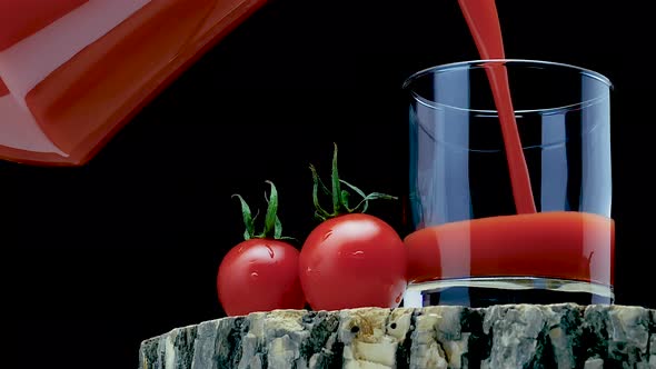 Pour Natural Tomato Juice Into A Glass On A Black Background. Fresh Tomatoes With Tomato Juice