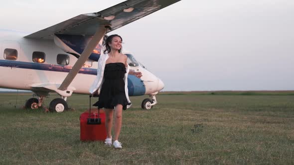 Portrait of a Beautiful Smiling Woman in a Hat Walking at the Airport on the Background of the Plane