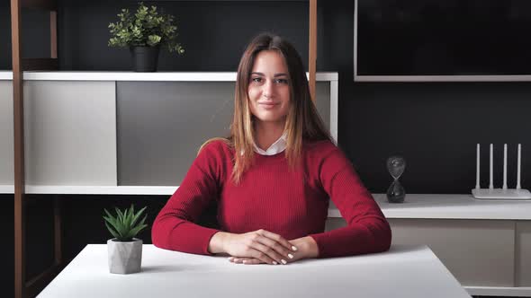 Portrait of a Young Woman Leader at the Work Desk Against the Background of a Modern Office