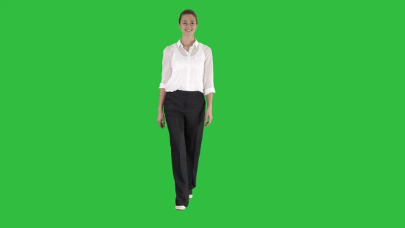 Formal young woman walking and smiling on a Green Screen