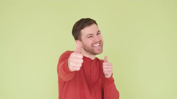 Handsome Man with a Beard in an Orange Sweater on a Yellowgreen Background