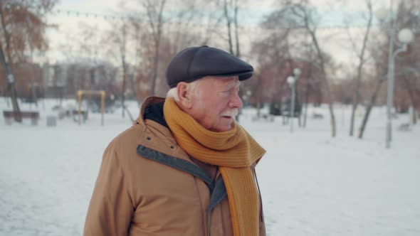 Aged Man Walking in Winter Park