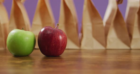 Animation of paper lunch bags an fruits on wooden table