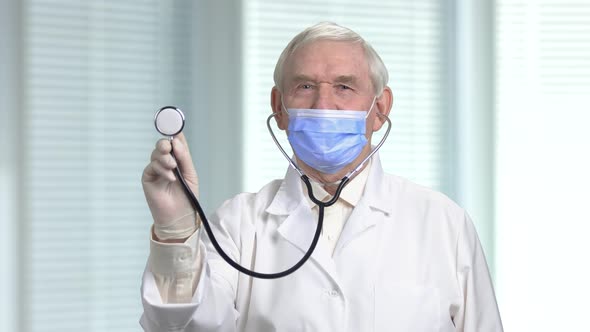 Senior Male Doctor with a Stethoscope Listening