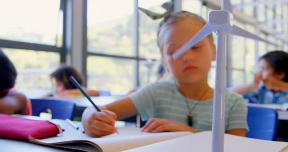 Caucasian schoolgirl studying at desk in classroom 4k