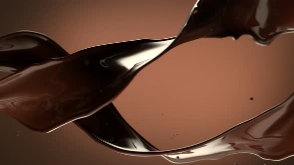 Super Slow Motion Shot of Twisting Chocolate Splashes on Brown Gradient Background at 1000 Fps