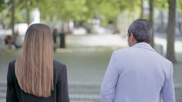 Back View of Man and Woman Walking Outdoors