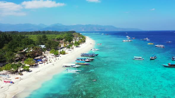 Paradise exotic beach with white sand in front of calm clear water of turquoise lagoon full of touri