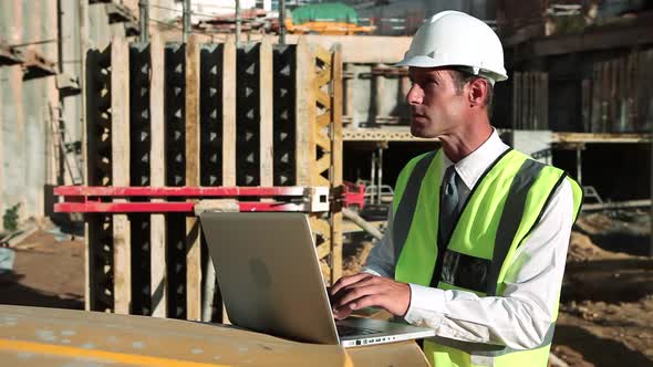 Mature Man Using Laptop on Construction Site