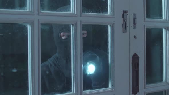 Close Up Of Thief Man Holding Flashlight Opening The Door And Entering Someone's House