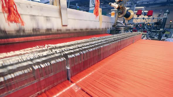 Weaving Mechanism with Lots of Red Threads Going Through It