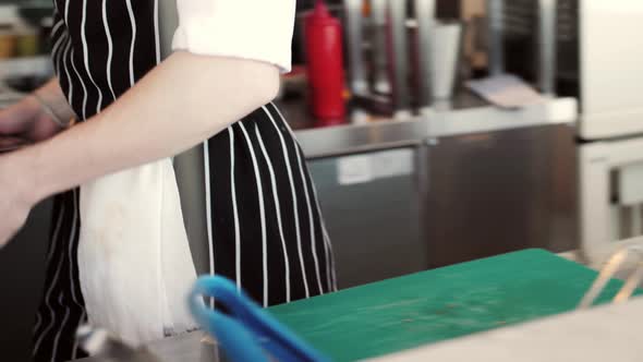 Chefs in Protective Masks and Gloves Prepare Food in the Kitchen of a Restaurant or Hotel High