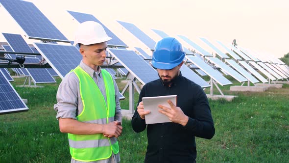 Supervising Engineer with a Worker Who Reads the Construction Plan