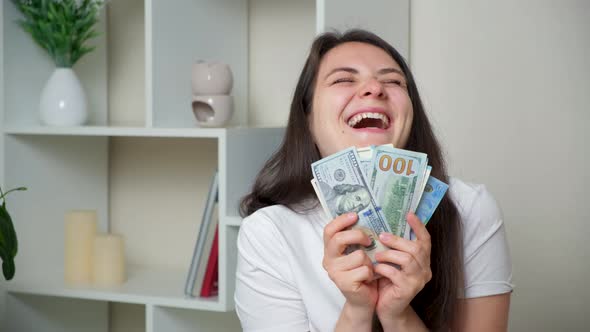 A Happy Woman Throws Up a Lot of Bills of Dollars and Euros and Laughs