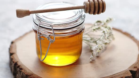 Glass Jar Full of Fresh Honey Placed on Slice of Wood
