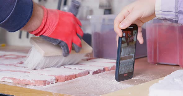 Man Records Video of Worker Sweeping Away Plaster Residue