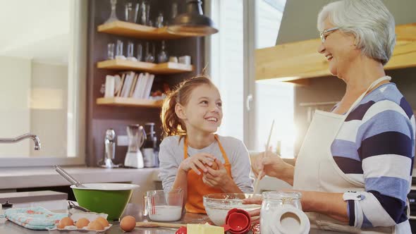 Happy grandma mixing mixture little girl standing besides her 4K 4k