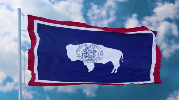 Wyoming Flag on a Flagpole Waving in the Wind Blue Sky Background