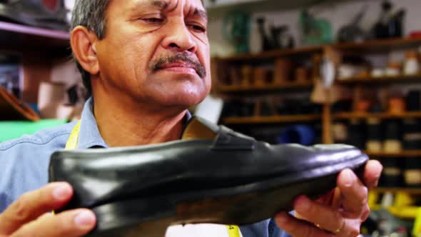 Cobbler examining a shoe in workshop