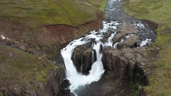 Split waterfalls in Iceland with drone video pulling out.