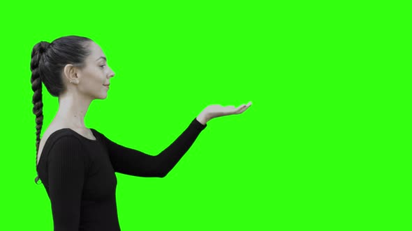 Young Woman Holding a Virtual Entity with Green Screen.