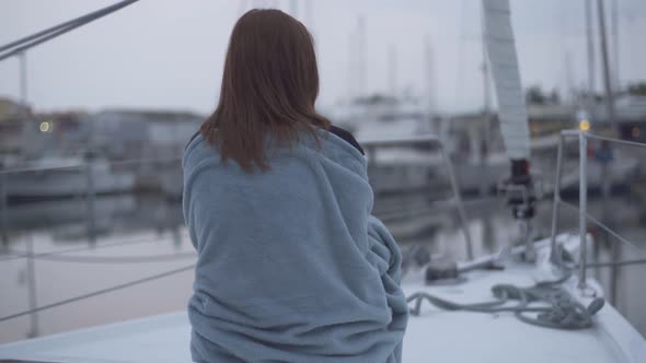 Beautiful Redhaired Woman Sitting in a Plaid on a Yacht in the French Port