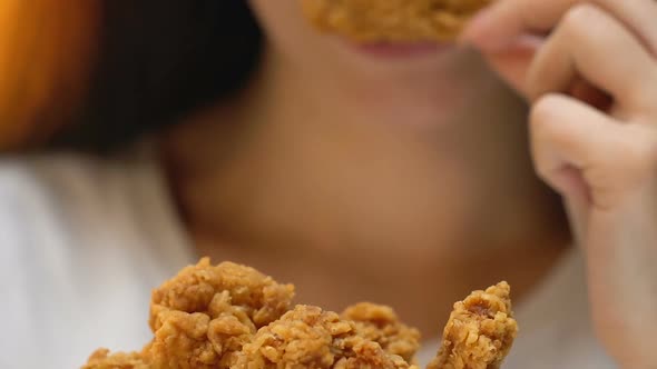 Satisfied Young Woman Eating Fatty Crispy Fried Chicken, Appetite, Close Up