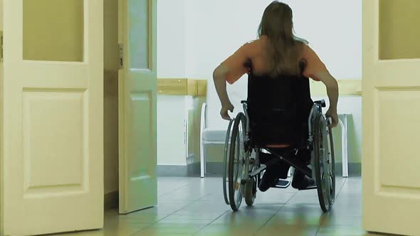 Young Guy Drives Through a Hospital Corridor on a Wheelchair 2